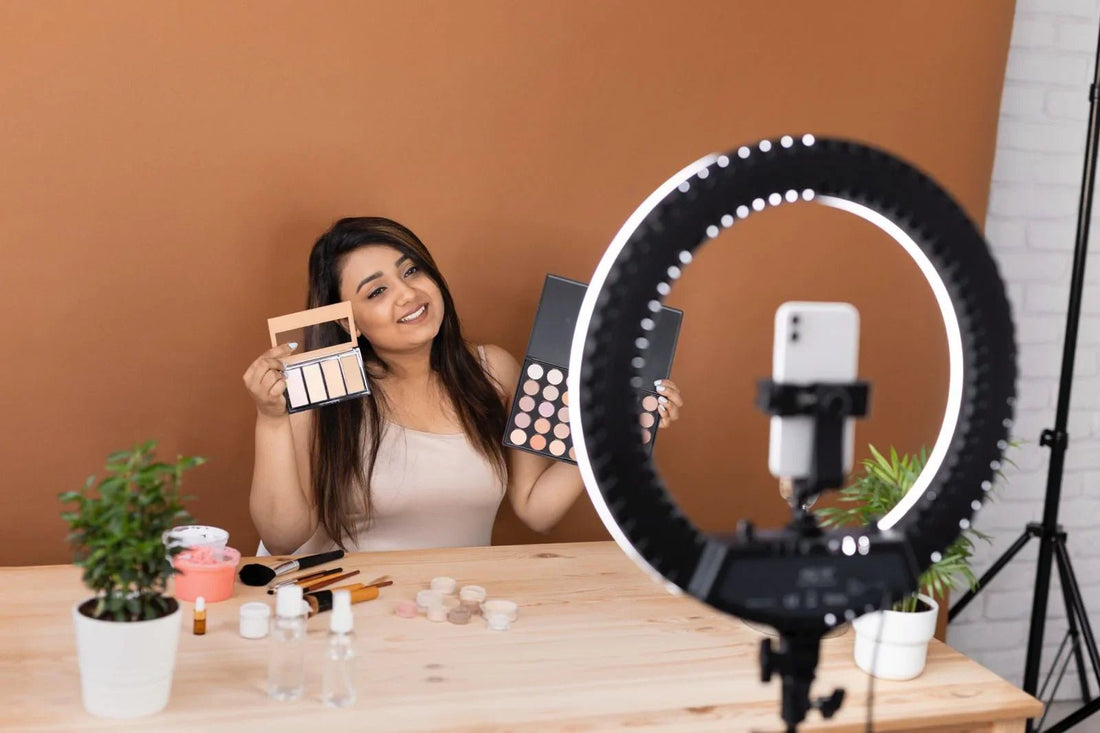 Beauty influencer showcasing eyeshadow palettes with ring light setup for makeup tutorial